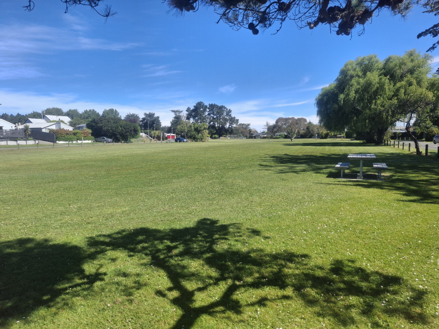 Open green space and picnic table at Waikuku Beach Oval